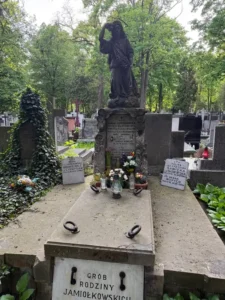 Stare nagrobki na cmentarzu z klasycznym posągiem kobiety trzymającej kwiaty