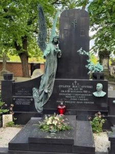 Stare nagrobki na cmentarzu z patynowanym aniołem i eleganckim ciemnym granitem