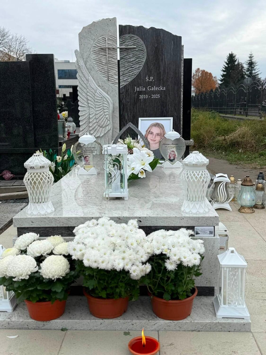 Trzy doniczki białych chryzantem przed nagrobkiem GRAAL z motywem serca i skrzydła