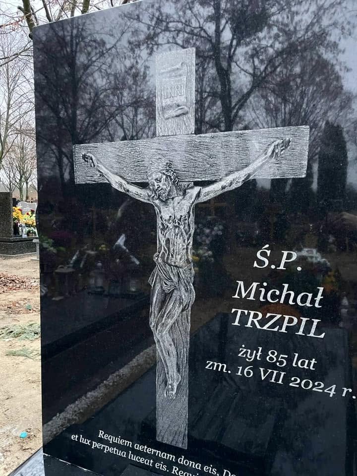 Ciemna tablica GRAAL z krzyżem po lewej, napisem po prawej i rzymskim oznaczeniem miesiąca VII