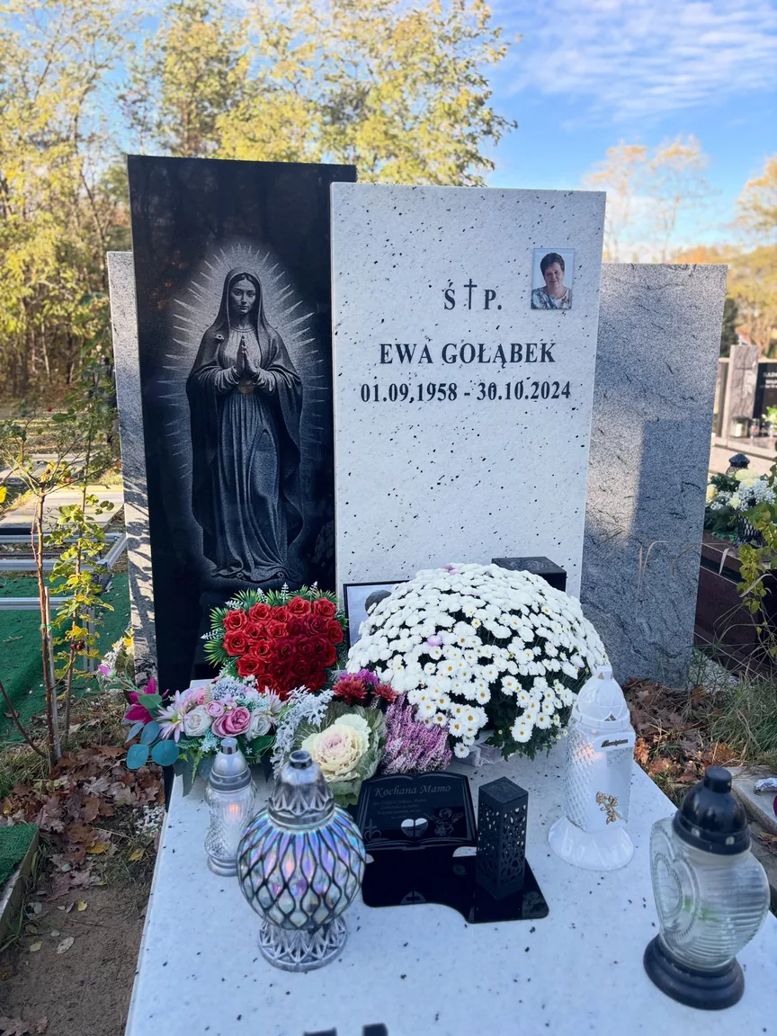 Bukiety, kwiaty i znicze na płycie przy tablicy z portretem — fotografia GRAAL