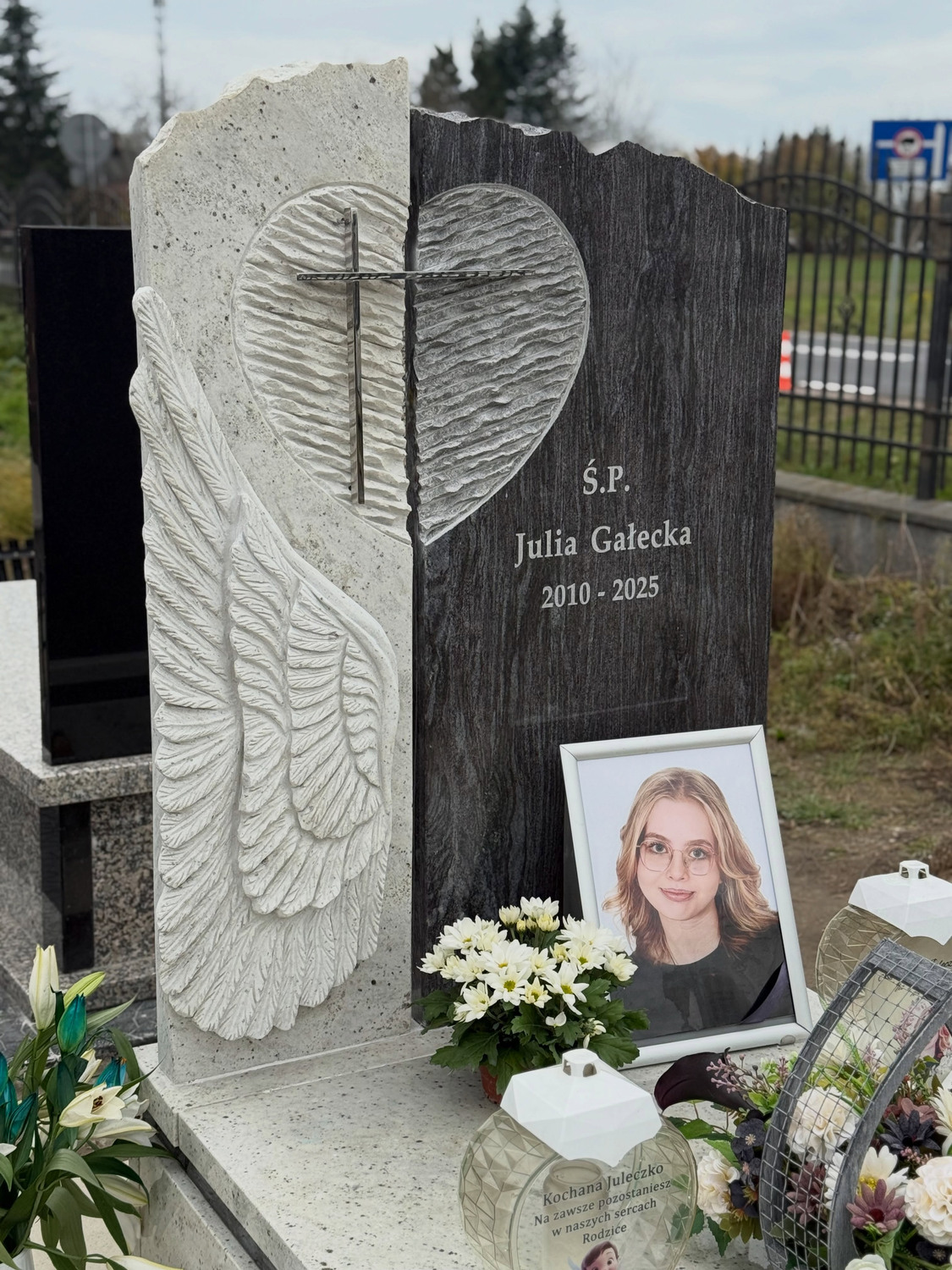 Rzeźbiony motyw serca, piór i krzyża przy ciemnym polu napisu — GRAAL